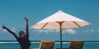 ombrellone bianco, lettini e donna felice