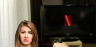 schermo tv nero con logo netflix e dona triste