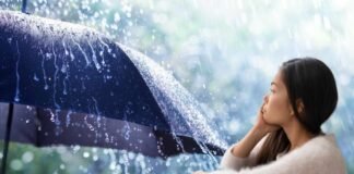 donna pensierosa e ombrello con pioggia