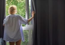 Tende oscuranti, è davvero una buona idea usarle anche in estate? La risposta lascia tutti perplessi donna che apre tenda