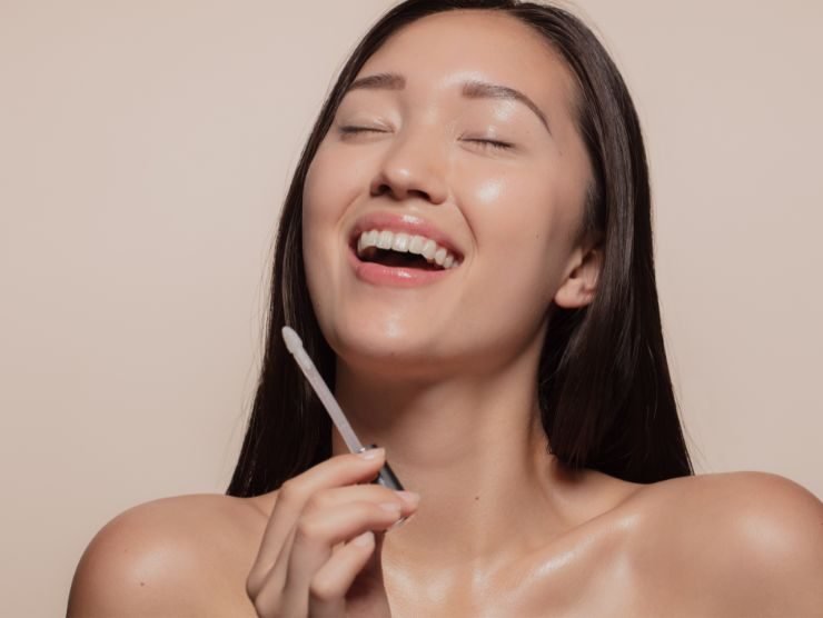 donna sorridente con matita make up in mano