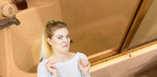 donna disgusta da una vasca da bagno molto sporca