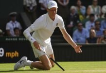 Jannik Sinner a terra dopo uno scambio a Wimbledon