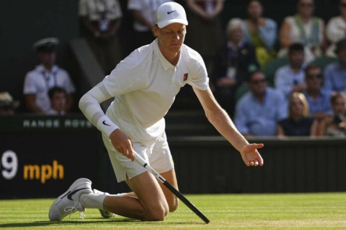 Jannik Sinner a terra dopo uno scambio a Wimbledon