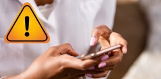 mani di donna con smartphone e segnale attenzione