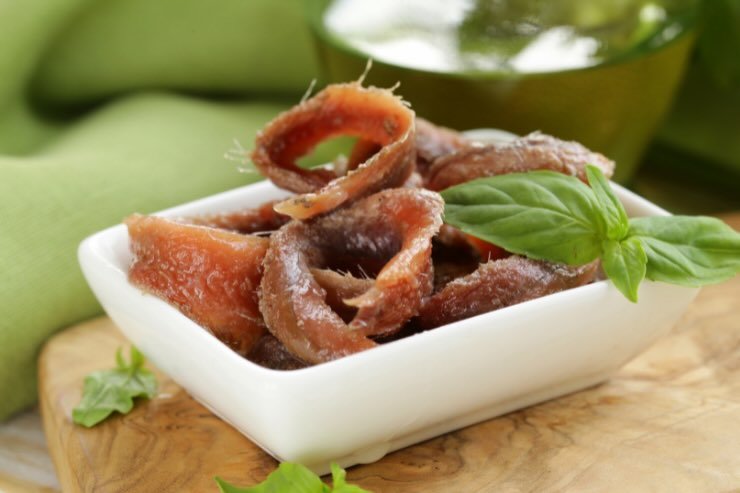 ciotola con filetti di acciughe e basilico