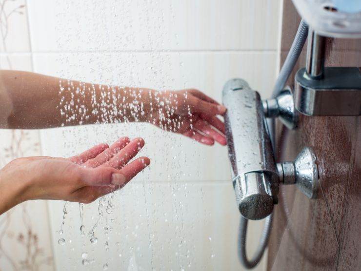 mani che sono sotto il getto della doccia