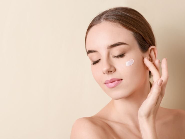 donna che mette crema sul viso