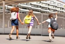 alunni con zaino che corrono dandosi le mani