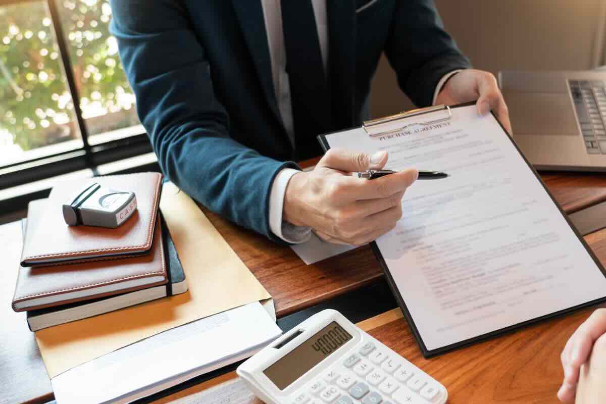 uomo che fa firma contratto con penna 