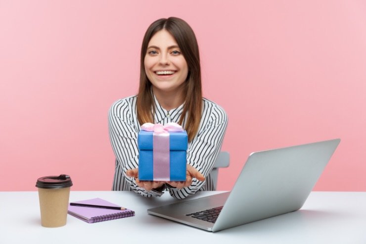 donna con pc e pacco regalo