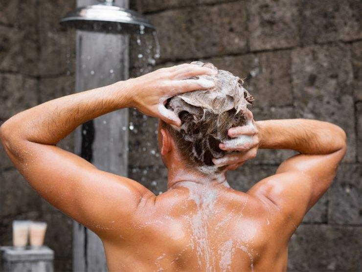 uomo che si fa la doccia e shampoo
