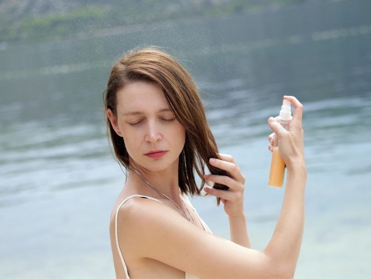 donna che mette dello spray nei capelli