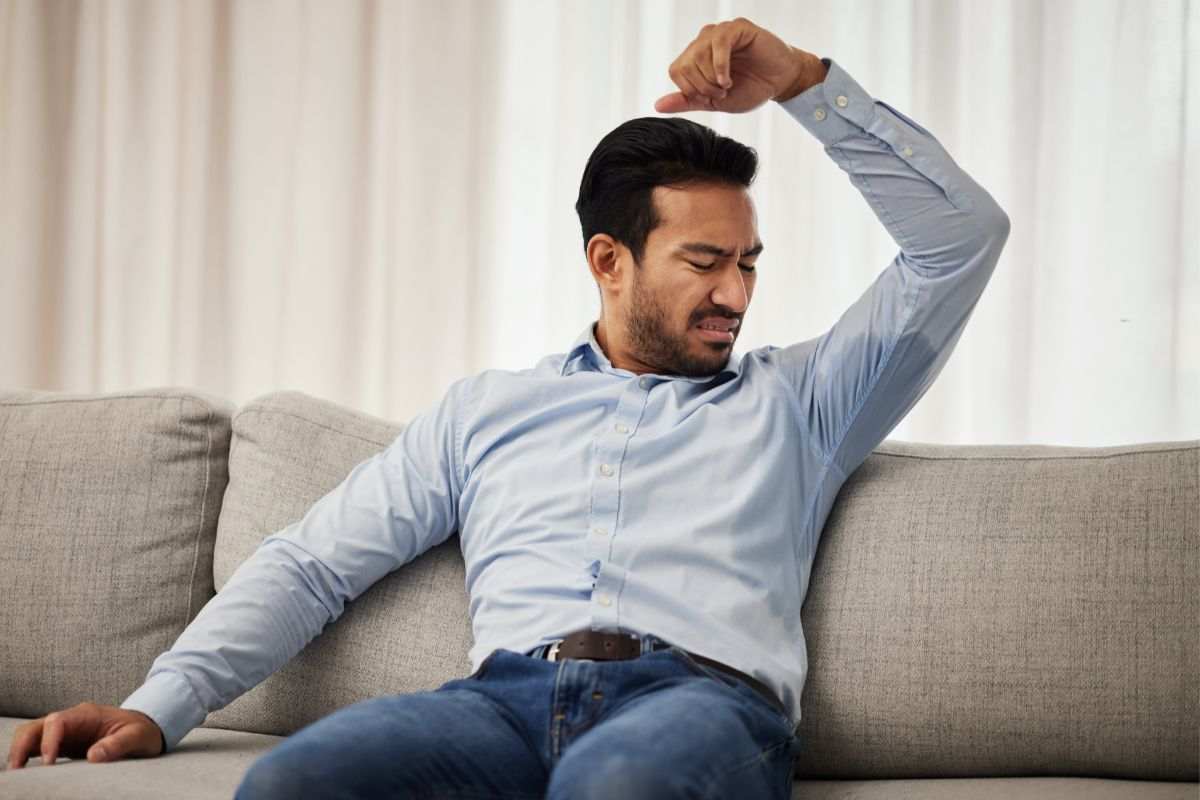 uomo che guarda come sta sudato sotto l'ascella