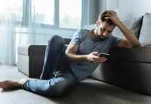 uomo al cellulare triste