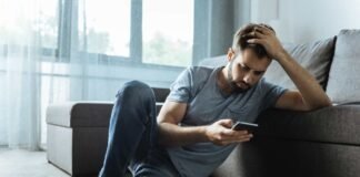 uomo al cellulare triste