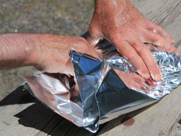 mani che maneggiano dei pezzetti di carta stagnola