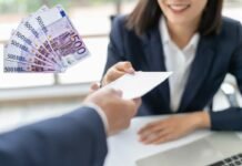 donna che sorride e porge una busta e banconote da 500 euro