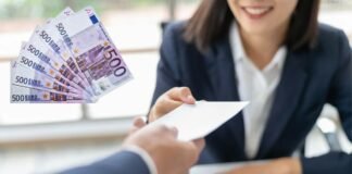 donna che sorride e porge una busta e banconote da 500 euro