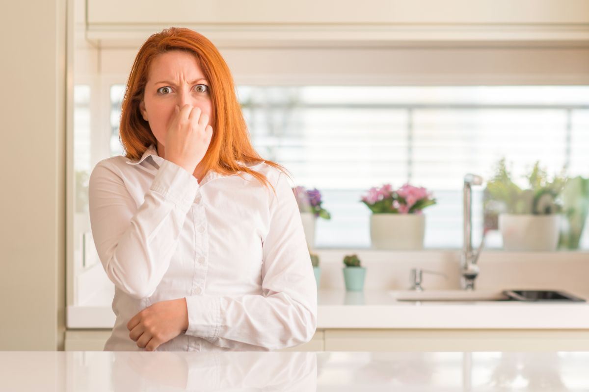 donna che si tappa il naso in cucina per la puzza