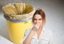 donna che si tappa il naso per il cattivo odore che proviene dalla pattumiera