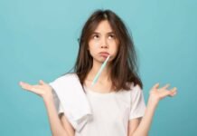 donna perplessa mentre si lava i denti