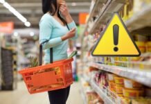 donna con cestino della spesa e segnale pericolo