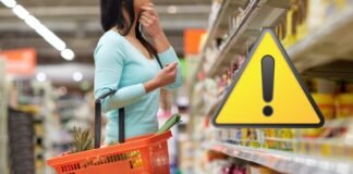 donna con cestino della spesa e segnale pericolo