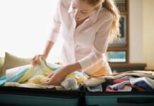 donna che controlla indumenti posti in una valigia