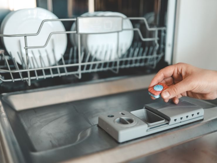 mano che mette pasticca nella lavastoviglie