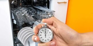 Prendi il cronometro e controlla: ci vorrà davvero solo 1 minuto per pulire la lavastoviglie lavastoviglie aperta e carica e mano che impugna un cronometro