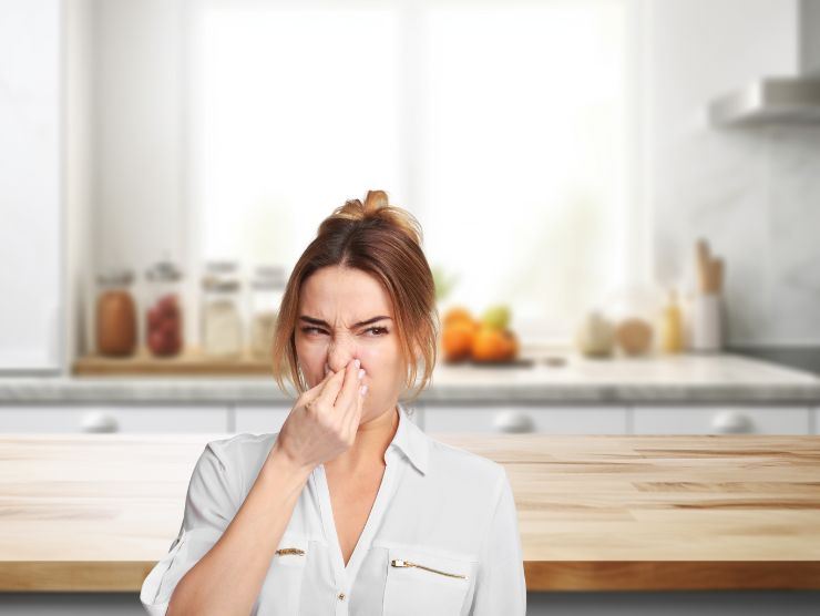 donna che si tappa il naso in cucina per la puzza