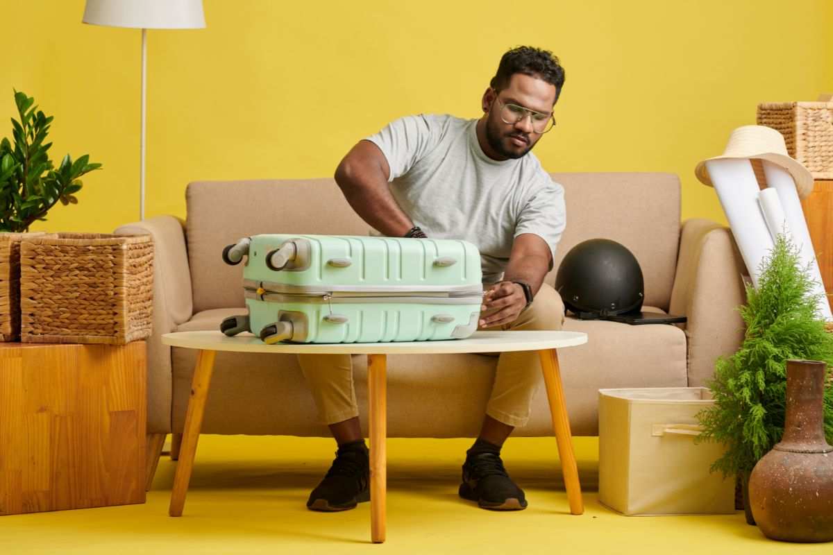 uomo che apre valigia su un tavolino