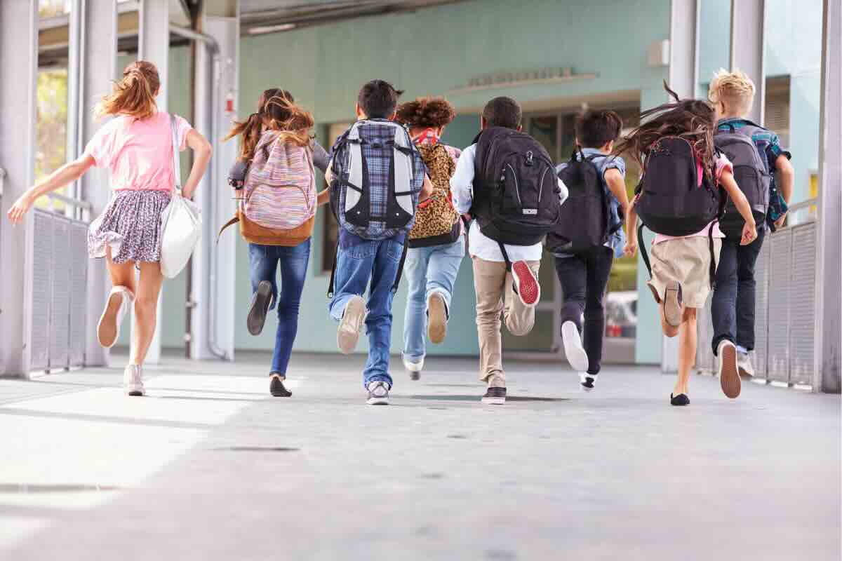 ragazzi che corrono con zaini 