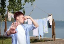 bucato steso all'aperto e ragazzo che si tappa il naso per la puzza