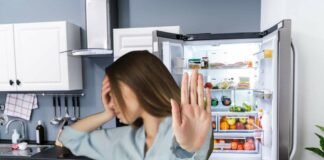 donna che dice no e frigorifero in cucina aperto