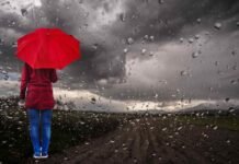 pioggia e donna di spalle con ombrello rosso
