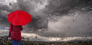 pioggia e donna di spalle con ombrello rosso