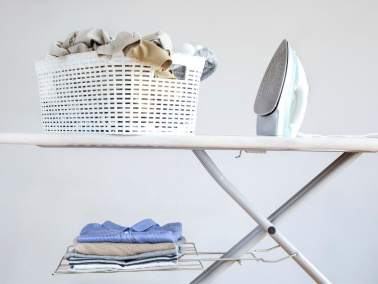 asse da stiro con panni da stirare, panni stirati e ferro da stiro