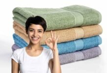 donna sorridente che fa ok e pila di asciugamani