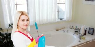 donna con prodotti di pulizia all'interno di un bagno