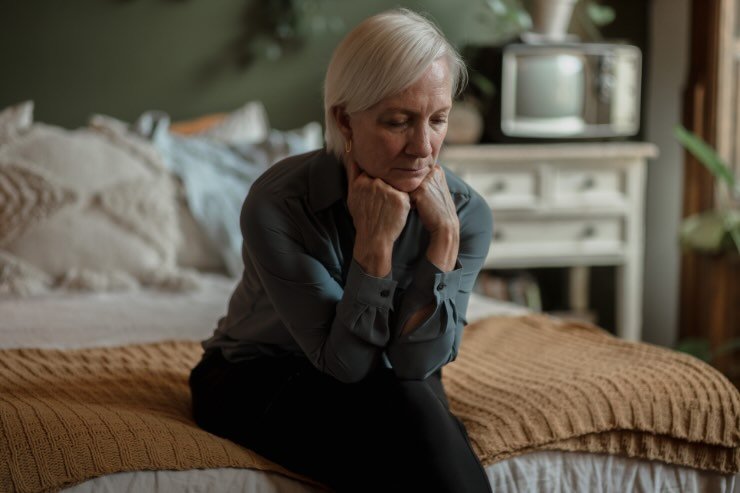 donna triste sul letto 