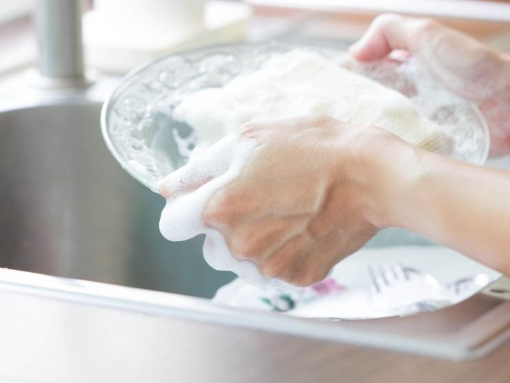 persona che sta lavando i piatti a mano