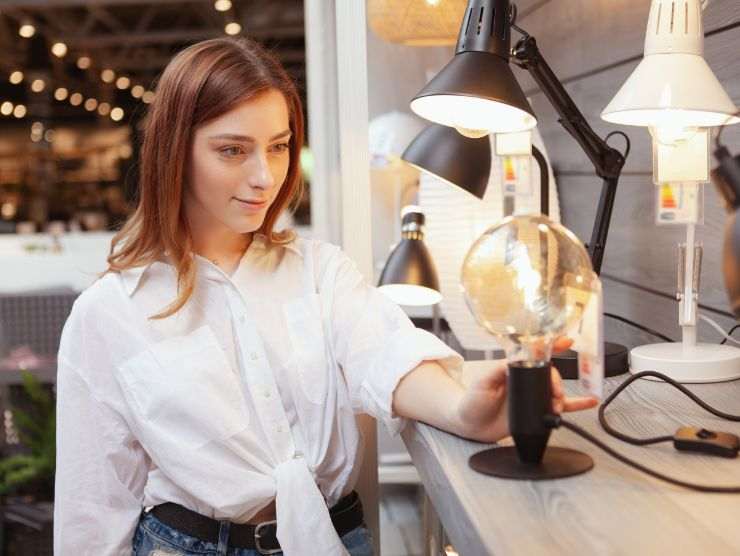 donna in un negozio di arredamento che sceglie una lue