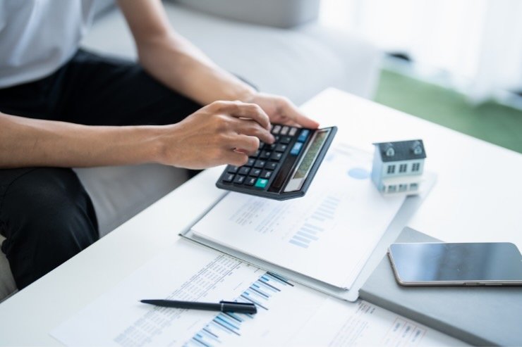 mani con calcolatrice e fogli