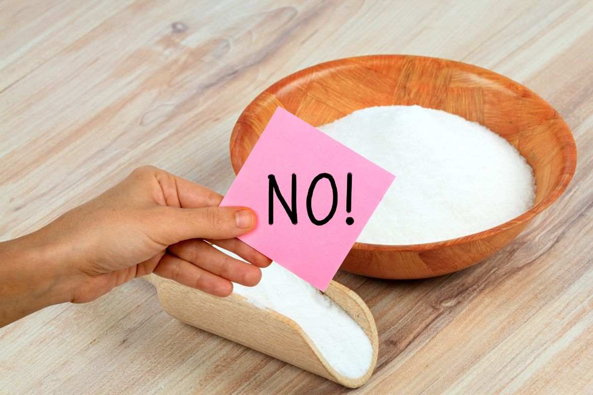 bicarbonato e mano che mantiene un post it con la scritta NO