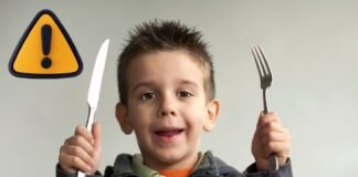 bambino con posate e segnale pericolo