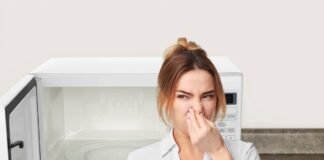 donna che si tappa il naso per la puzza che esce dal microonde