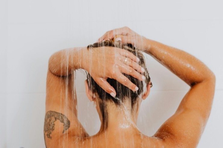 persona di spalle che fa la doccia