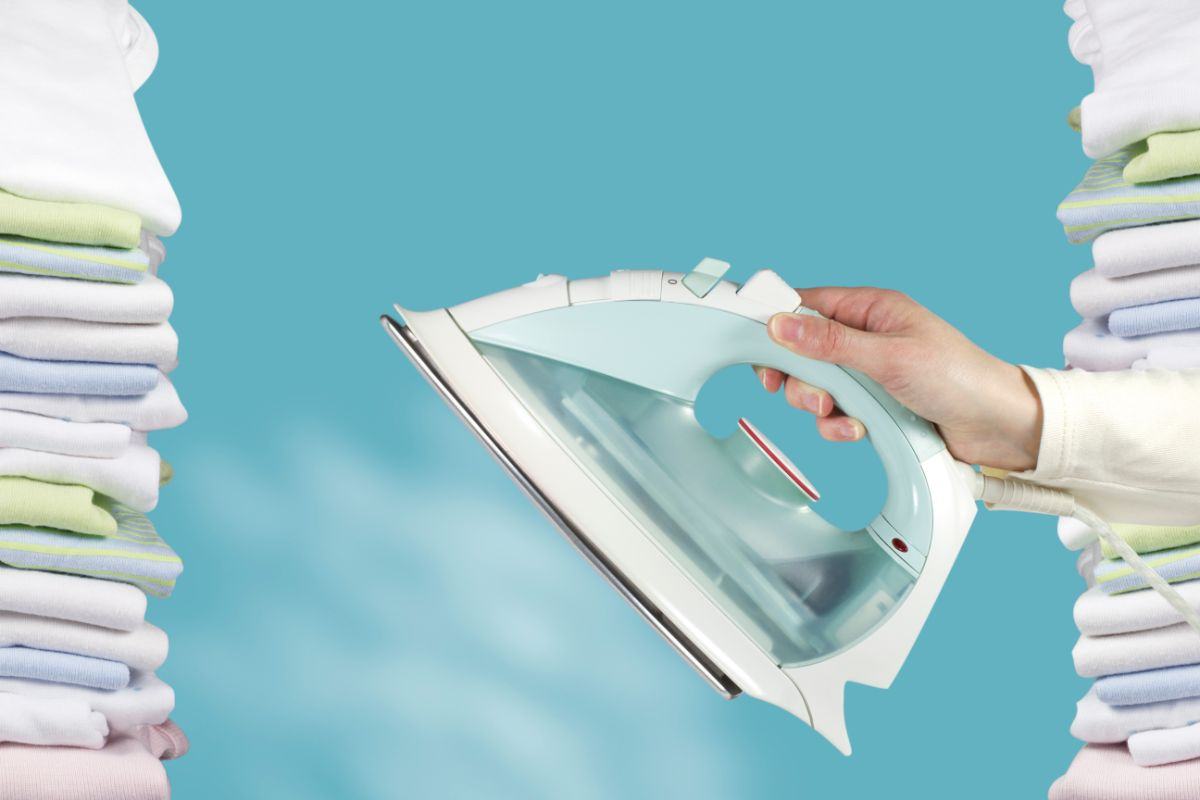 mano che impugna ferro da stiro che caccia vapore